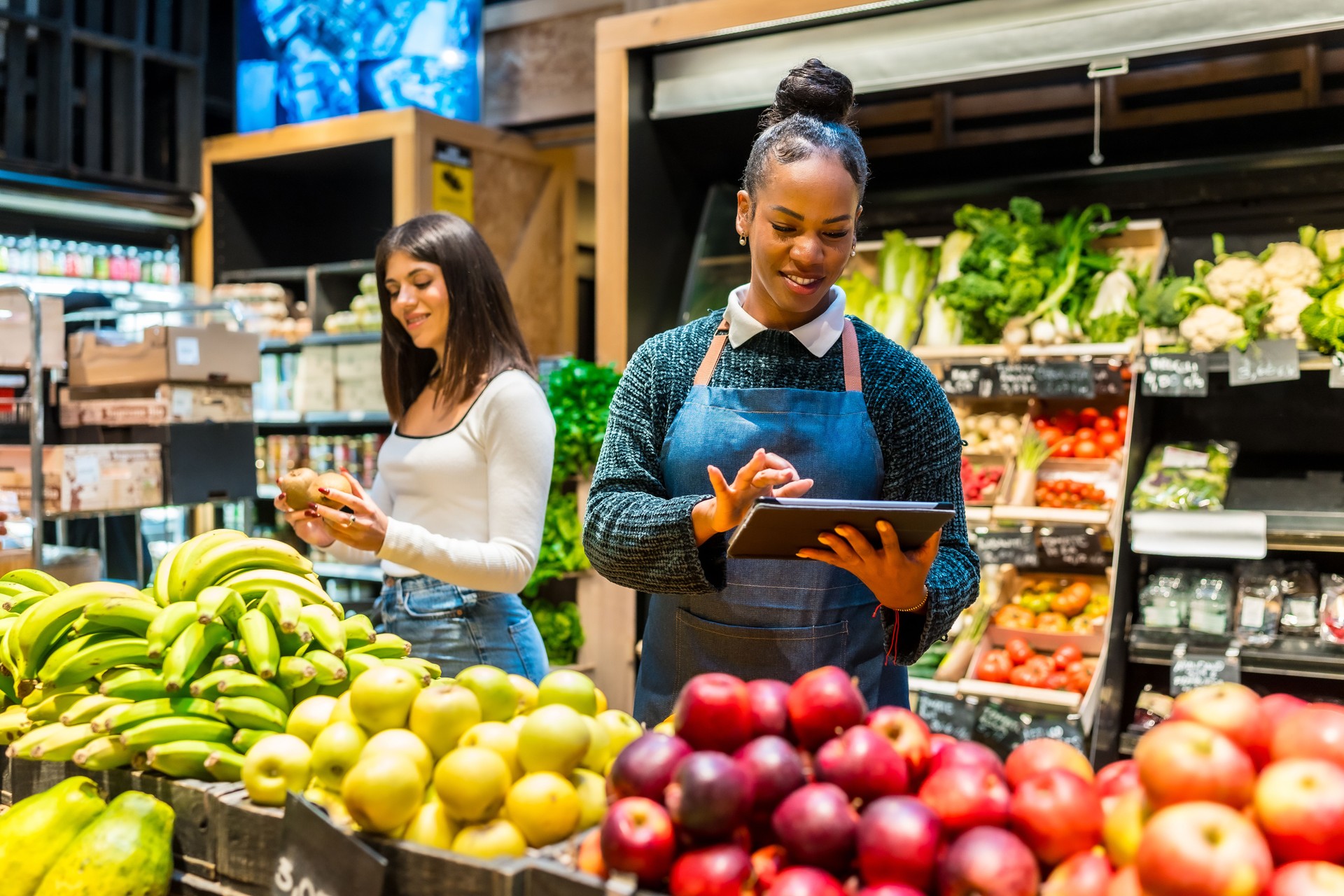 Saleswoman using digital tablet while working at organic supermarket